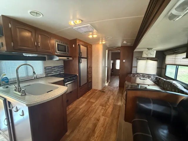 a kitchen with kitchen island granite countertop lots of counter top space and stainless steel appliances