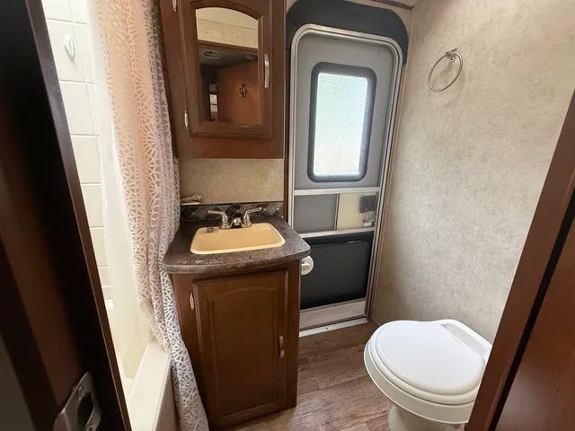 a bathroom with a toilet a sink and mirror
