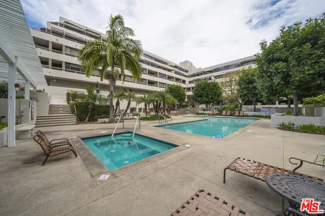 a view of a swimming pool with a patio and a yard
