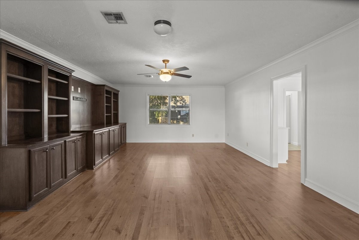 105 Alice Street Anahuac, TX 77514 - Photo 24 of 36 an empty room with wooden floor and windows