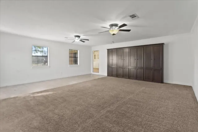 a view of an empty room with a ceiling fan