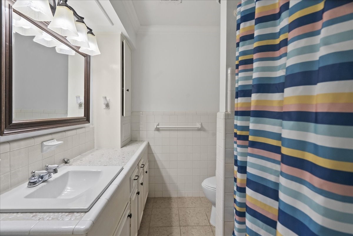 105 Alice Street Anahuac, TX 77514 - Photo 28 of 36 a bathroom with a sink a toilet and a mirror