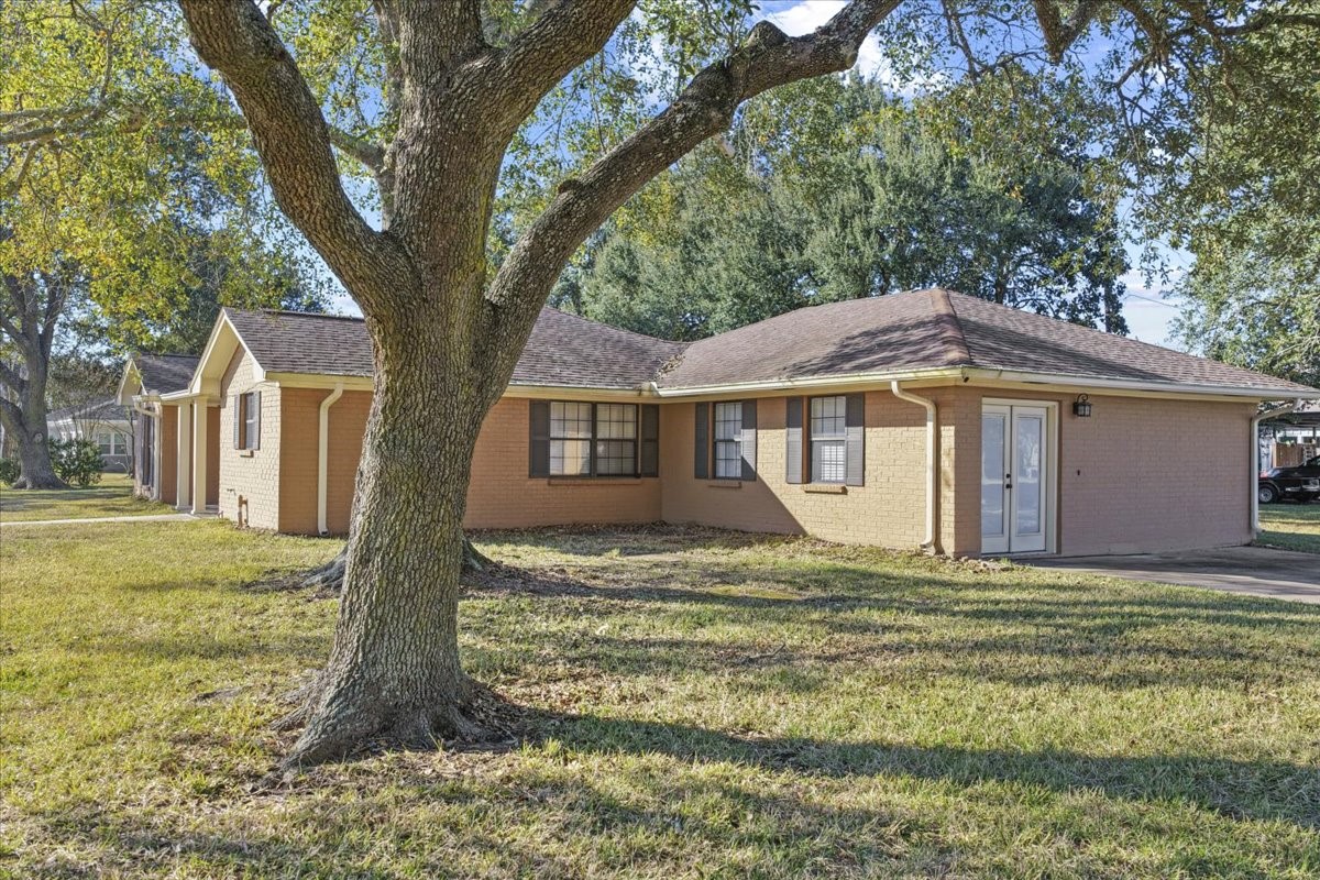 105 Alice Street Anahuac, TX 77514 - Photo 30 of 36 a house with green field in front of it