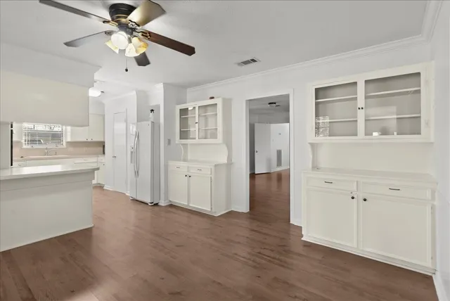 a view of a kitchen with wooden floor and a ceiling fan