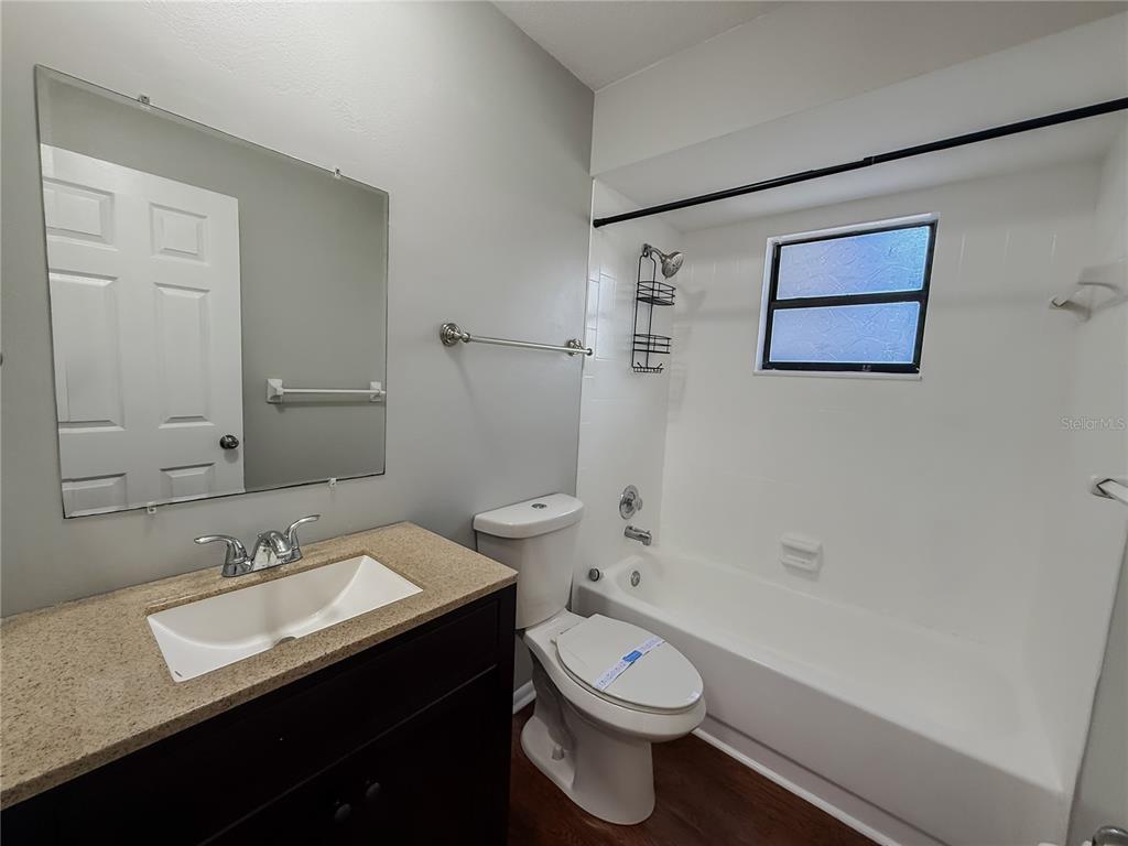 5364 Deltona Boulevard Spring Hill, FL 34606 - Photo 16 of 36 a bathroom with a granite countertop sink a toilet and a bathtub