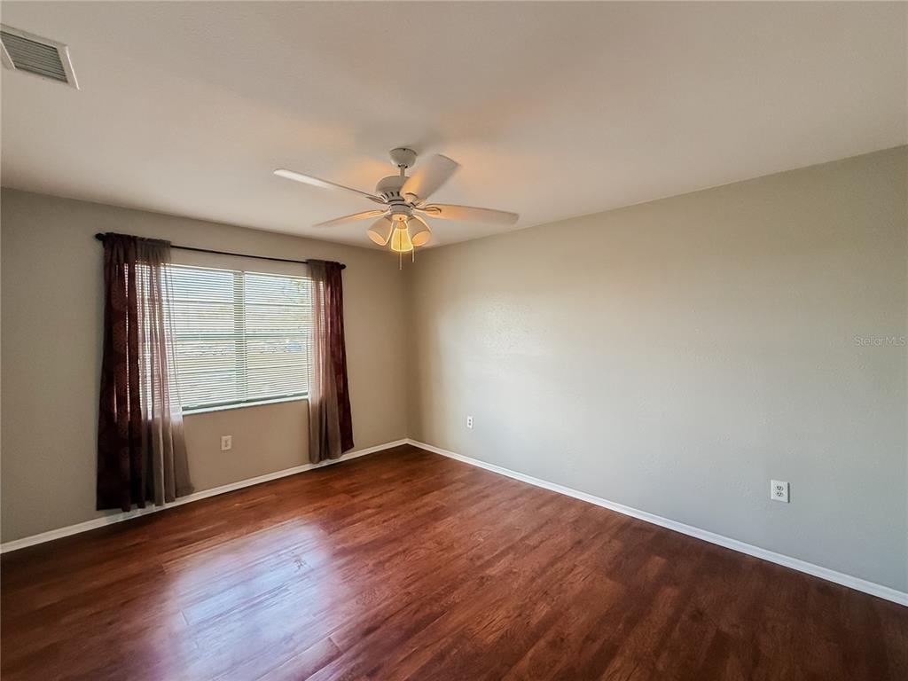 5364 Deltona Boulevard Spring Hill, FL 34606 - Photo 17 of 36 a view of an empty room with wooden floor and a window