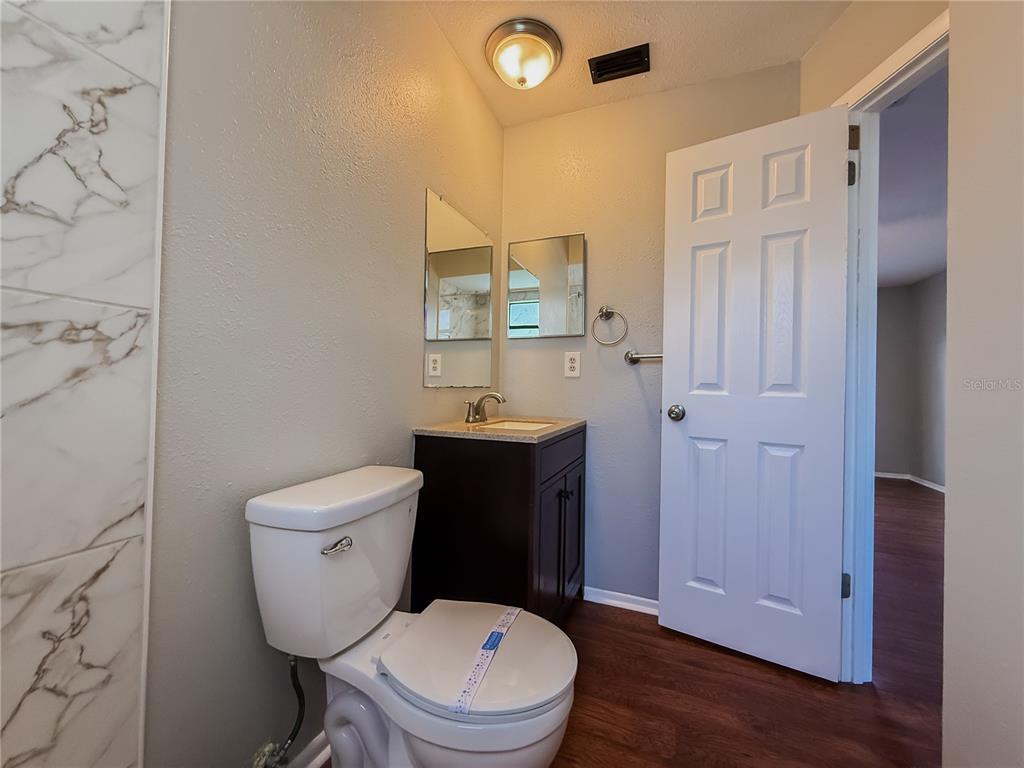 5364 Deltona Boulevard Spring Hill, FL 34606 - Photo 21 of 36 a bathroom with a toilet a sink and mirror