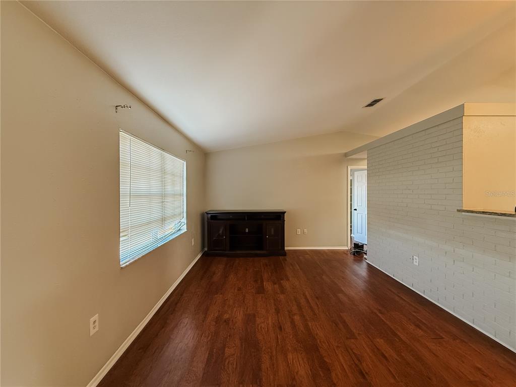 5364 Deltona Boulevard Spring Hill, FL 34606 - Photo 4 of 36 an empty room with wooden floor and windows
