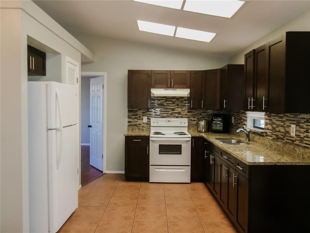5364 Deltona Boulevard Spring Hill, FL 34606 - Photo 8 of 36 a kitchen with a stove sink and refrigerator