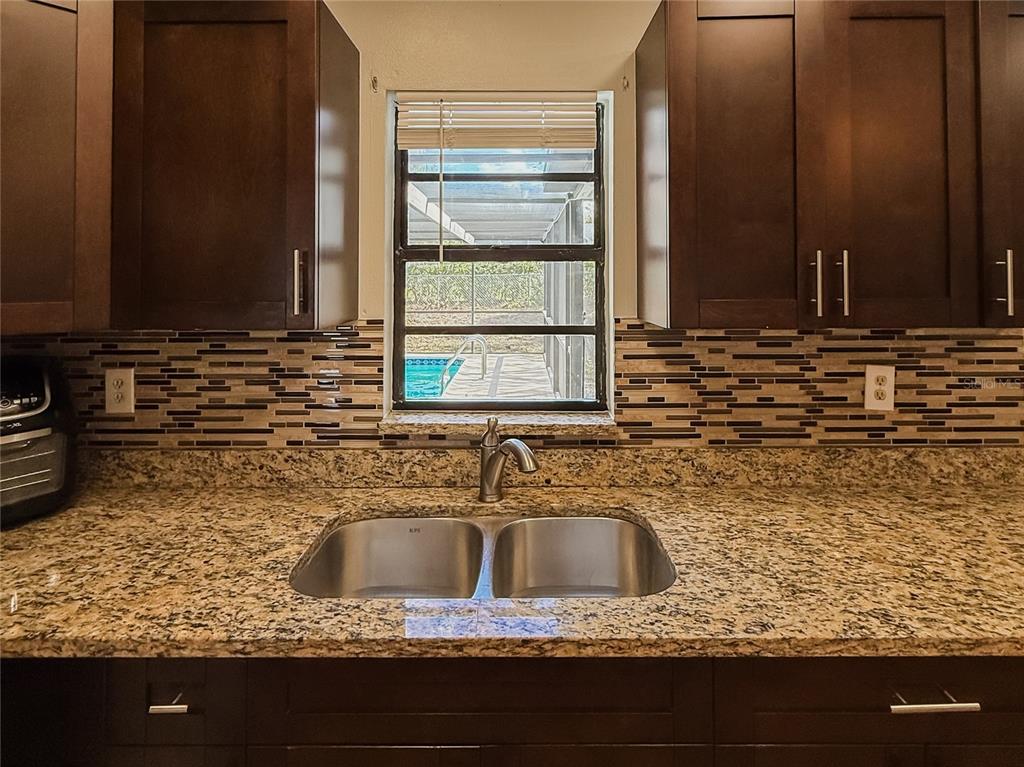 5364 Deltona Boulevard Spring Hill, FL 34606 - Photo 10 of 36 a kitchen sink with granite countertop a sink and cabinets