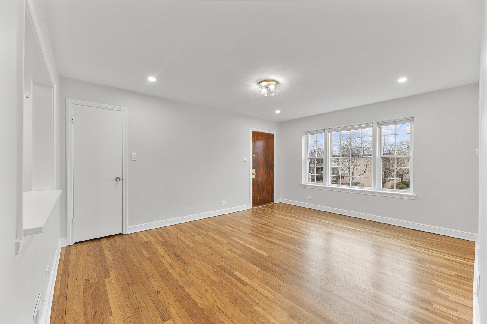 132 Ridge Avenue, Unit 2 Evanston, IL 60202 - Photo 3 of 14 a view of an empty room with wooden floor and a window