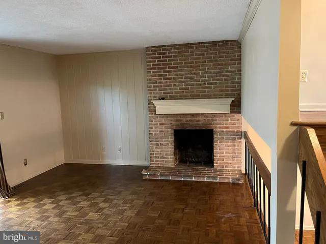 a view of empty room with fireplace and wooden floor