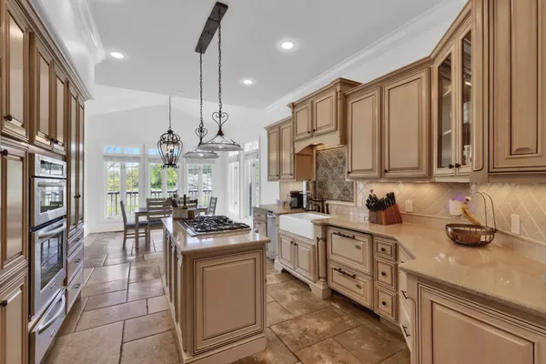a kitchen with stainless steel appliances granite countertop a refrigerator a stove and a wooden floors