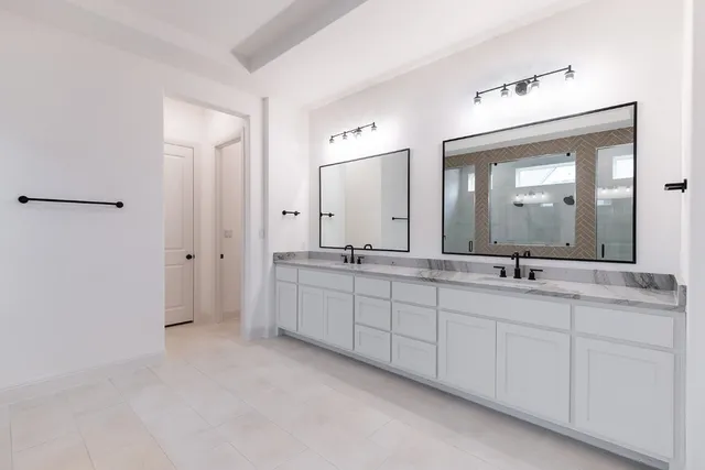 a bathroom with double sink and a mirror