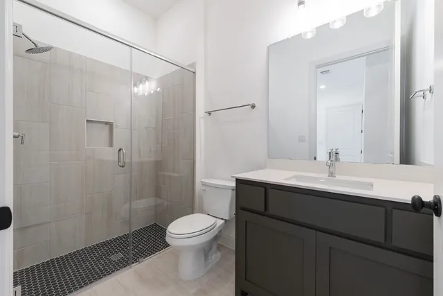 a bathroom with a sink a toilet and shower