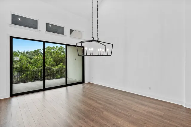 a view of a room with wooden floor fan and window