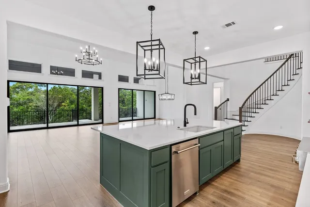 a kitchen with sink and large windows