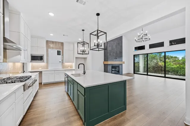a kitchen with granite countertop a sink stove and cabinets
