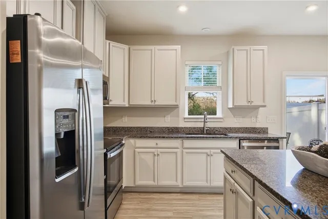 a kitchen with stainless steel appliances granite countertop a refrigerator sink and cabinets