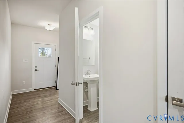 a view of a hallway with wooden floor and closet