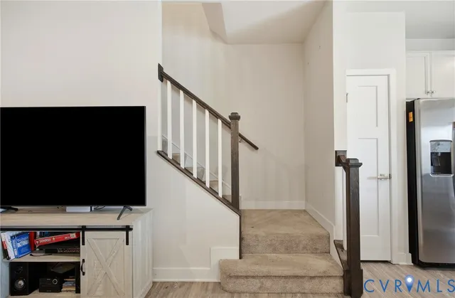 a view of a livingroom with wooden floor and staircase