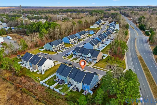 an aerial view of a house with a garden and lake view