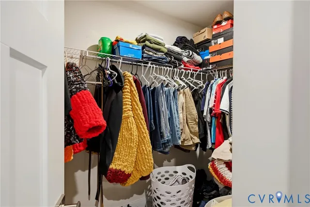 a view of walk in closet with clothes and shoes