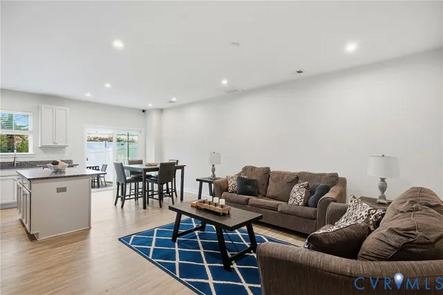 a living room with furniture a dining table and kitchen view