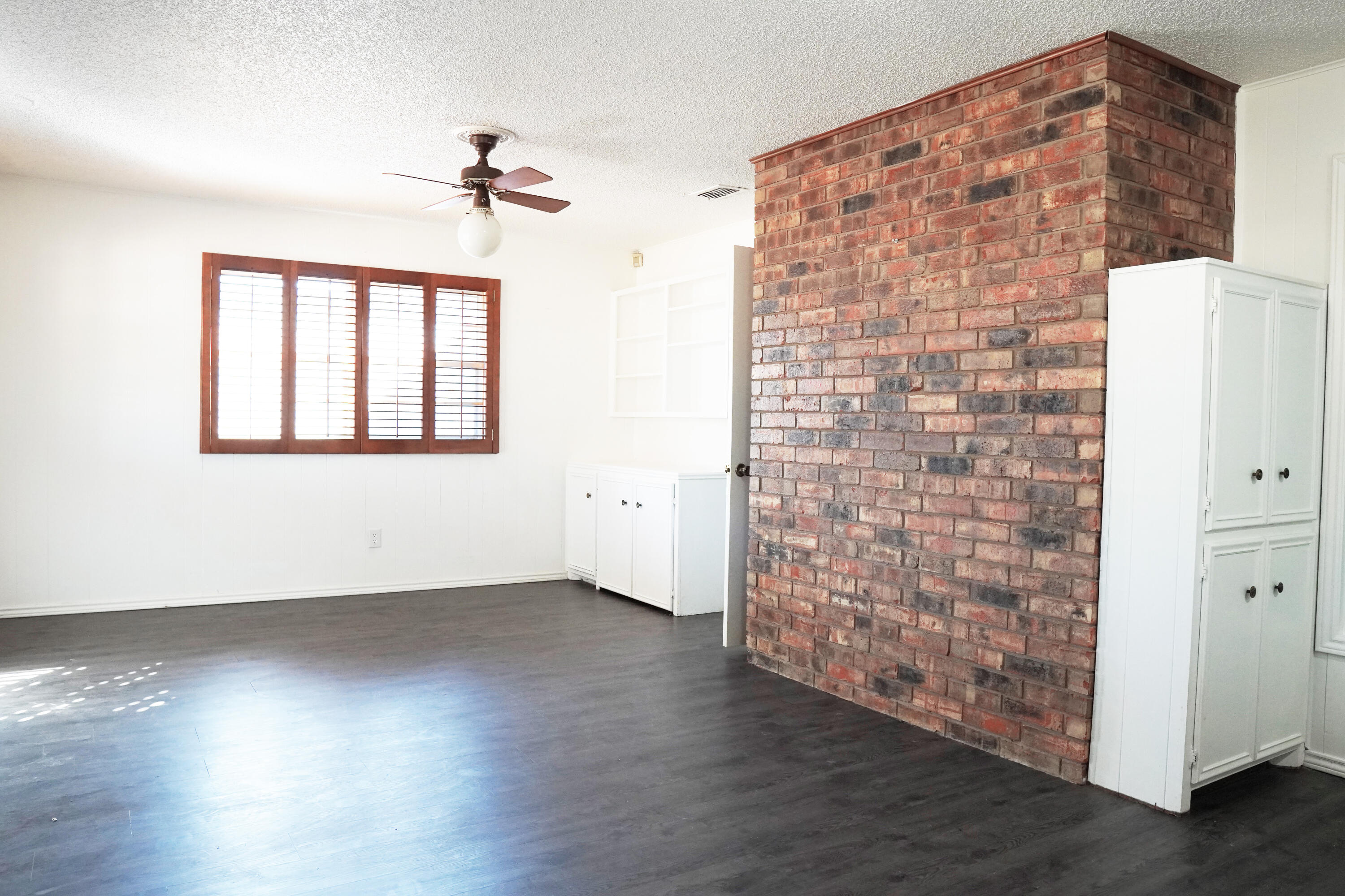 5520 80th Street Lubbock, TX 79424 - Photo 23 of 29 an empty room with wooden floor chandelier and windows