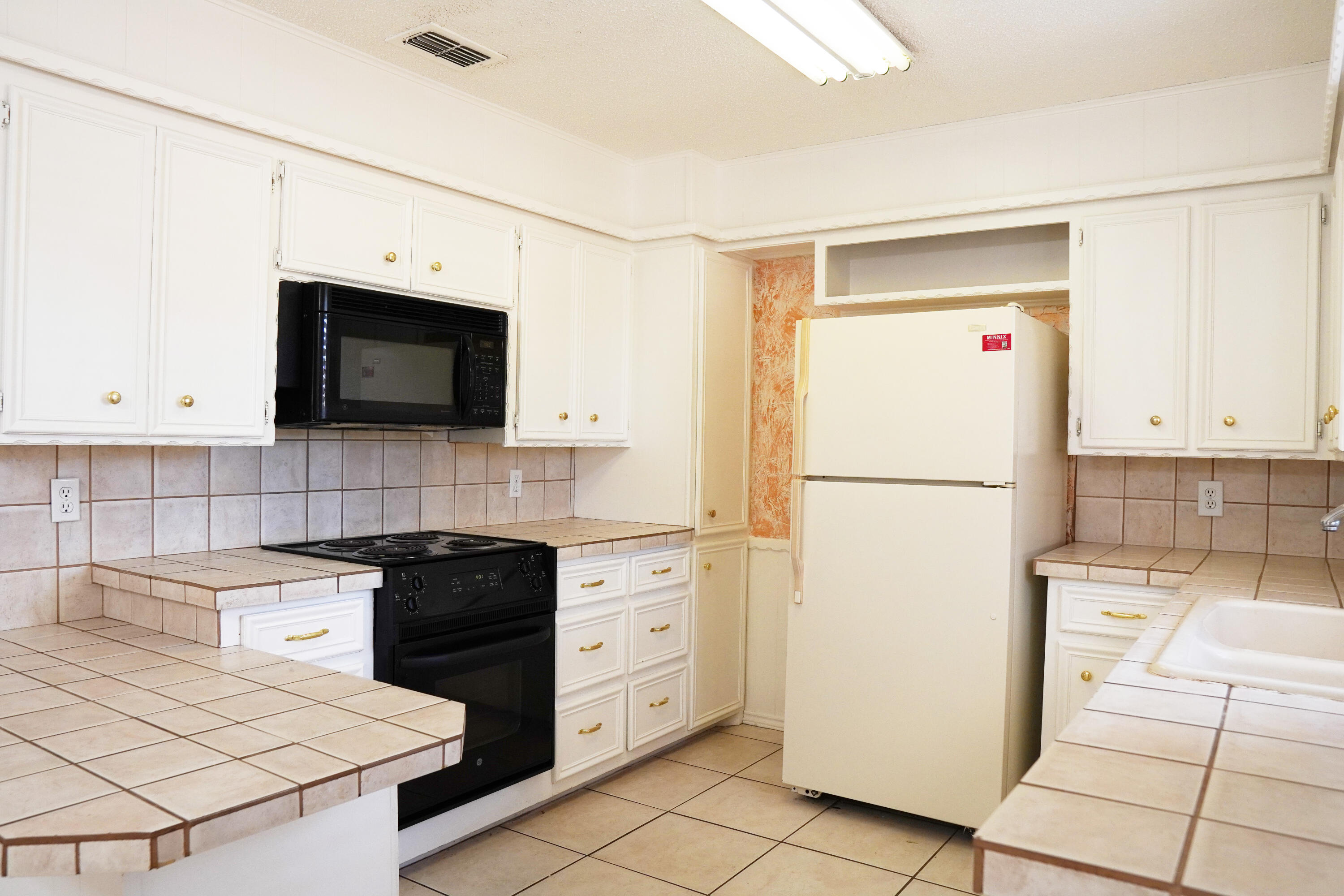 5520 80th Street Lubbock, TX 79424 - Photo 8 of 29 a kitchen with a refrigerator a stove top oven a sink and cabinets