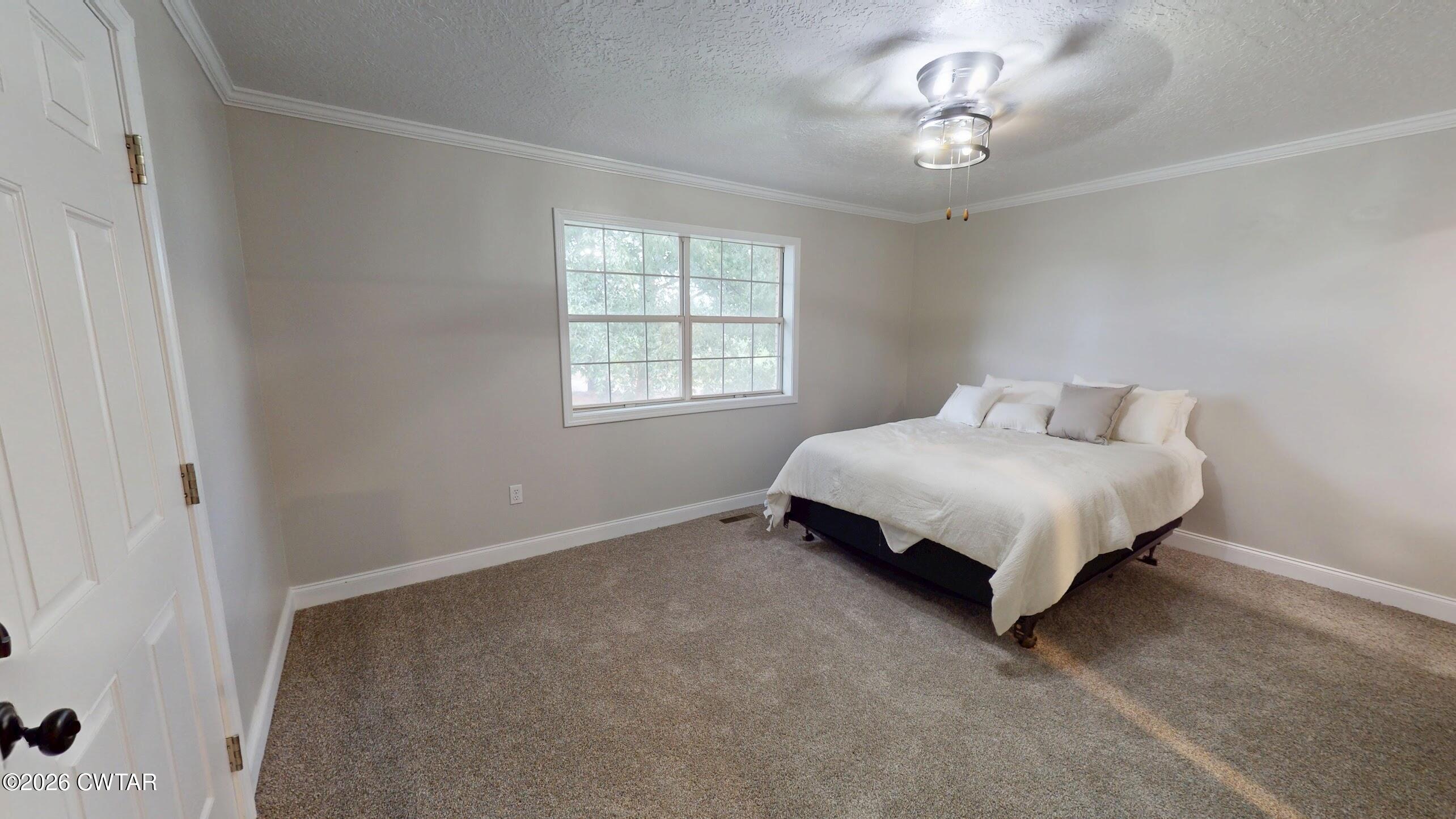 2800 Locust Grove Road Newbern, TN 38059 - Photo 33 of 46 a spacious bedroom with a bed and a chandelier