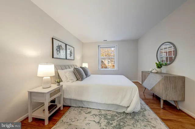 a bedroom with a bed a mirror and a window