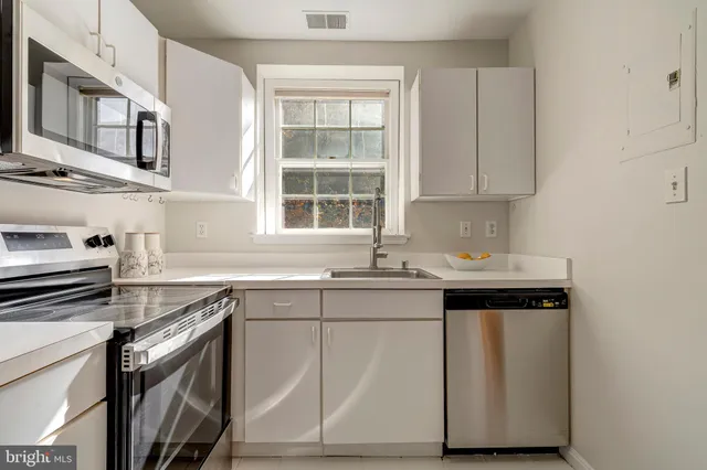 a kitchen with stainless steel appliances granite countertop a sink stove and cabinets