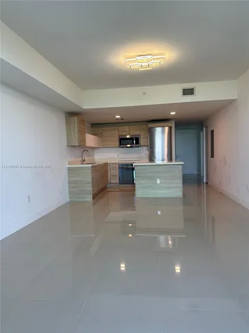 a large kitchen with stainless steel appliances a large counter top