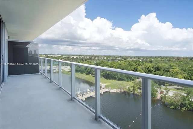 a view of a ocean with boats and trees in the background