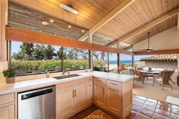 a kitchen with a sink a counter top space stainless steel appliances cabinets and a large window