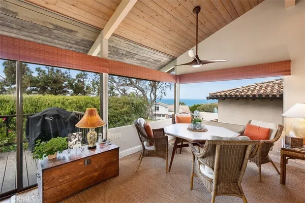 a dining room with furniture and a floor to ceiling window