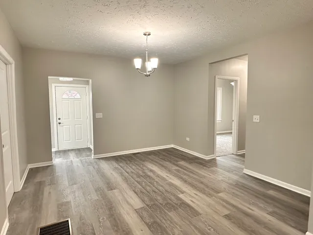 an empty room with wooden floor and mirror
