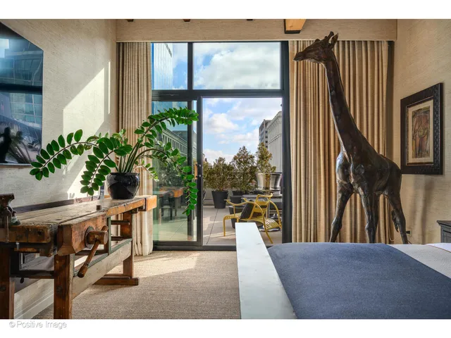 a bedroom with a bed a couch and potted plants