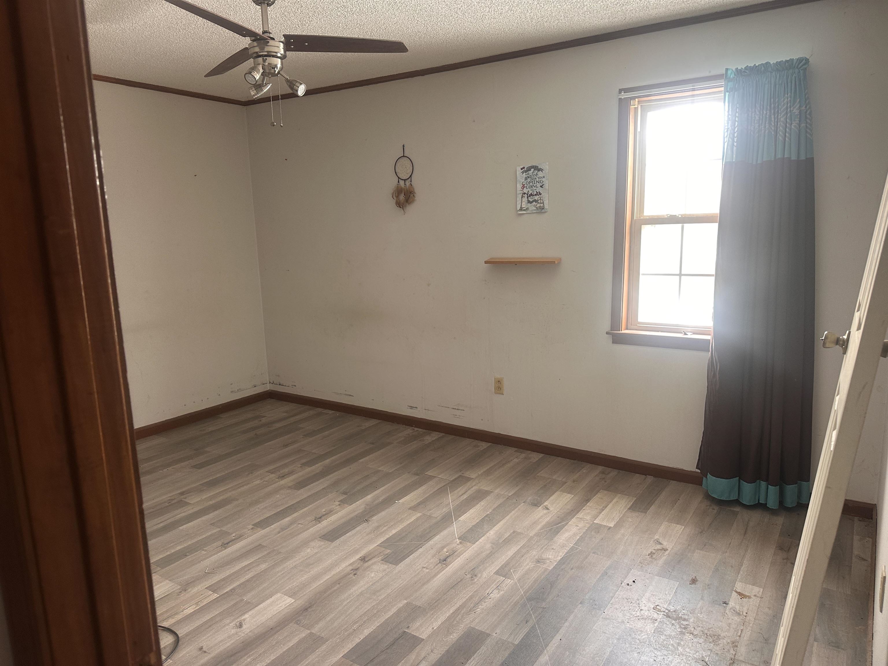 605 Jr Drive Covington, TN 38019 - Photo 17 of 21 Spare room with a ceiling fan, light wood finished floors, a textured ceiling, and crown molding