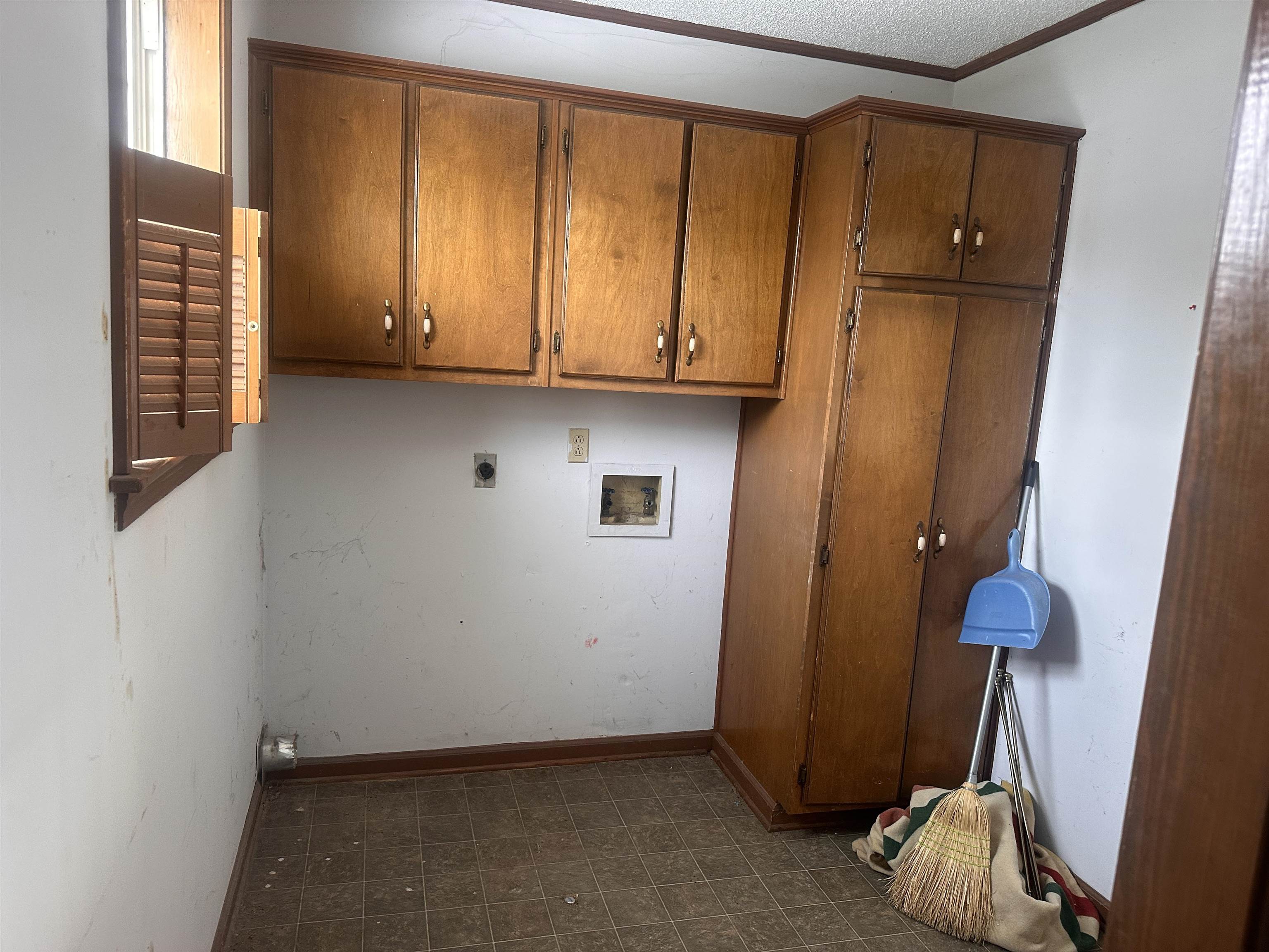 605 Jr Drive Covington, TN 38019 - Photo 19 of 21 Laundry room with hookup for a washing machine, cabinet space, dark flooring, hookup for an electric dryer, and crown molding