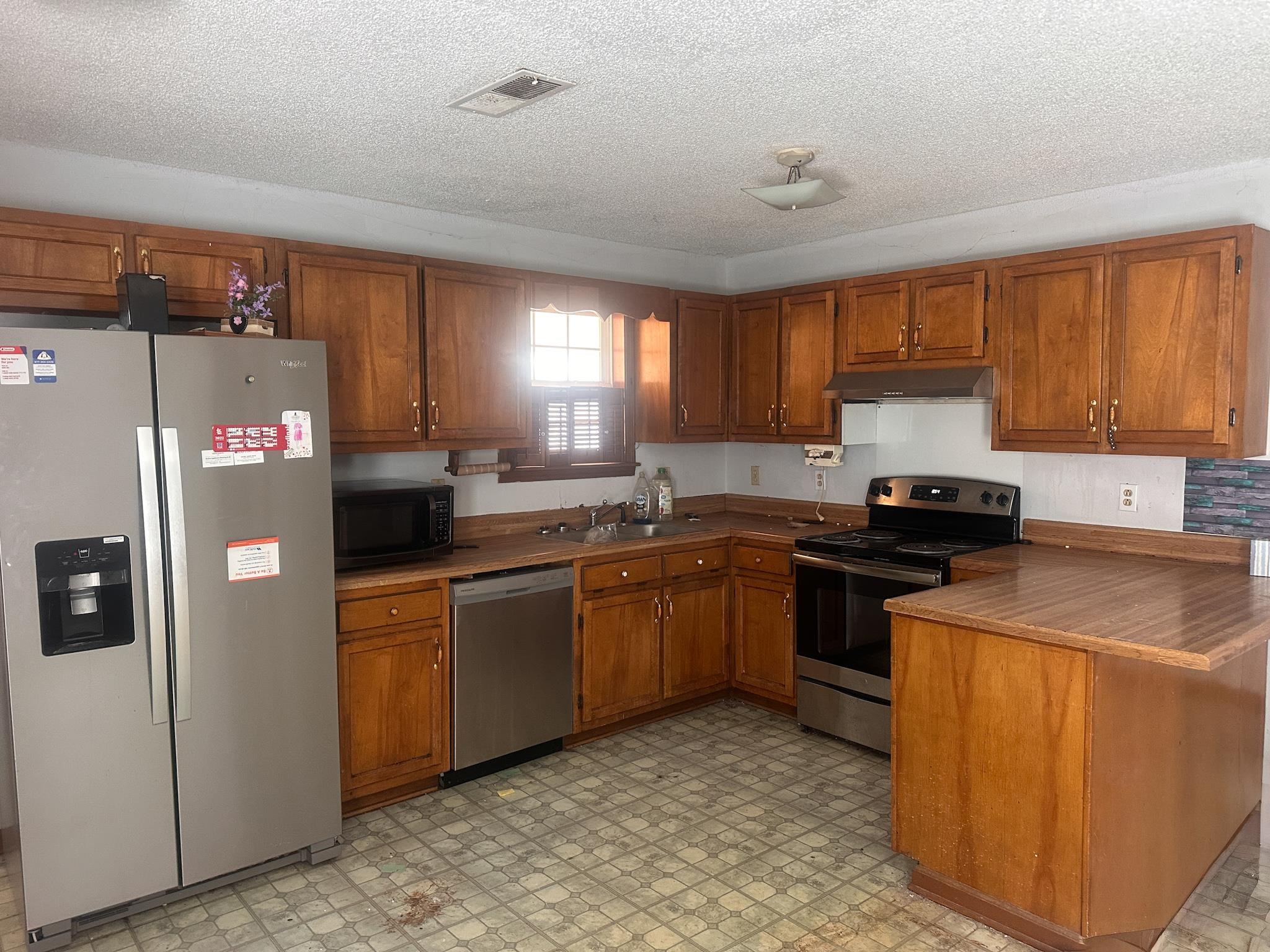 605 Jr Drive Covington, TN 38019 - Photo 8 of 21 Kitchen featuring stainless steel appliances, wood finish cabinets, a peninsula, light floors, and dark countertops