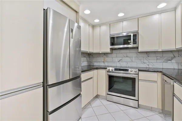 a kitchen with white cabinets and sink
