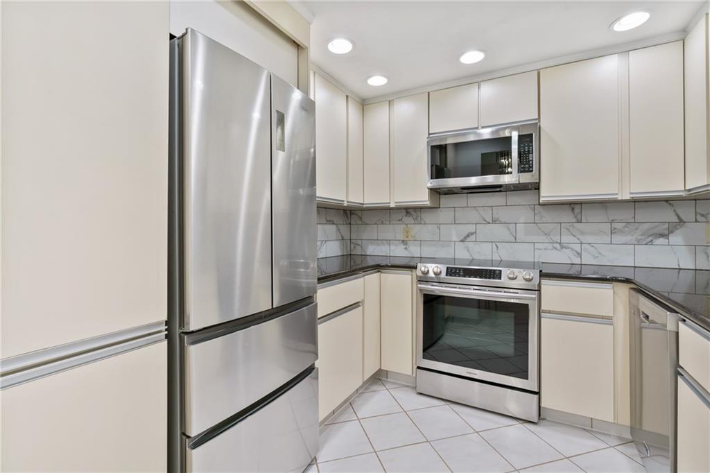 5600 Munhall Road, Unit 203 Pittsburgh, PA 15217 - Photo 13 of 31 a kitchen with white cabinets stainless steel appliances and a sink