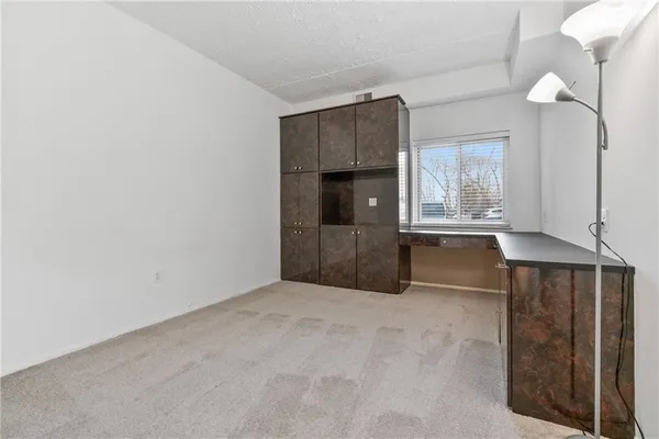 a view of an empty room with a kitchen