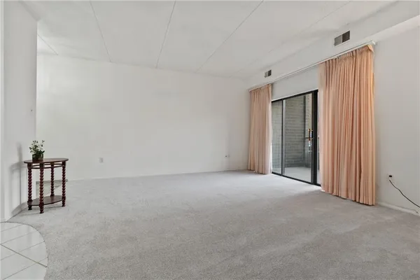 a view of empty room with cabinet and window