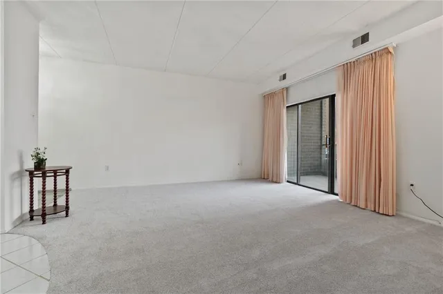 a view of empty room with cabinet and window