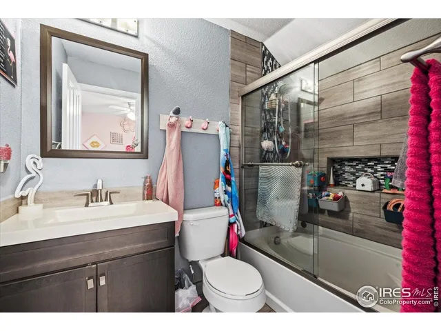 a bed sitting in a bedroom next to a window with a chandelier