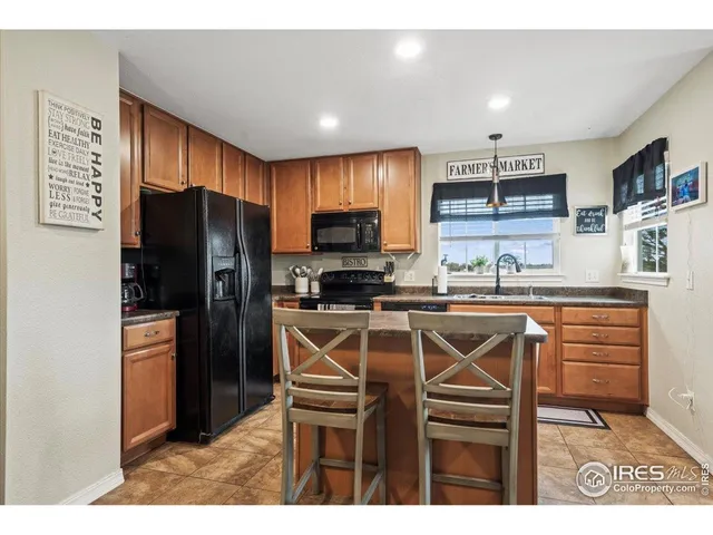 a kitchen with stainless steel appliances kitchen island granite countertop a refrigerator and a stove top oven
