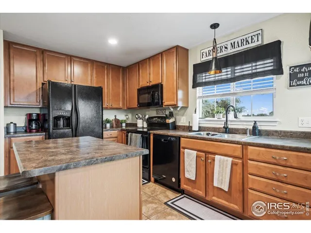 a kitchen with kitchen island granite countertop a sink stove and refrigerator